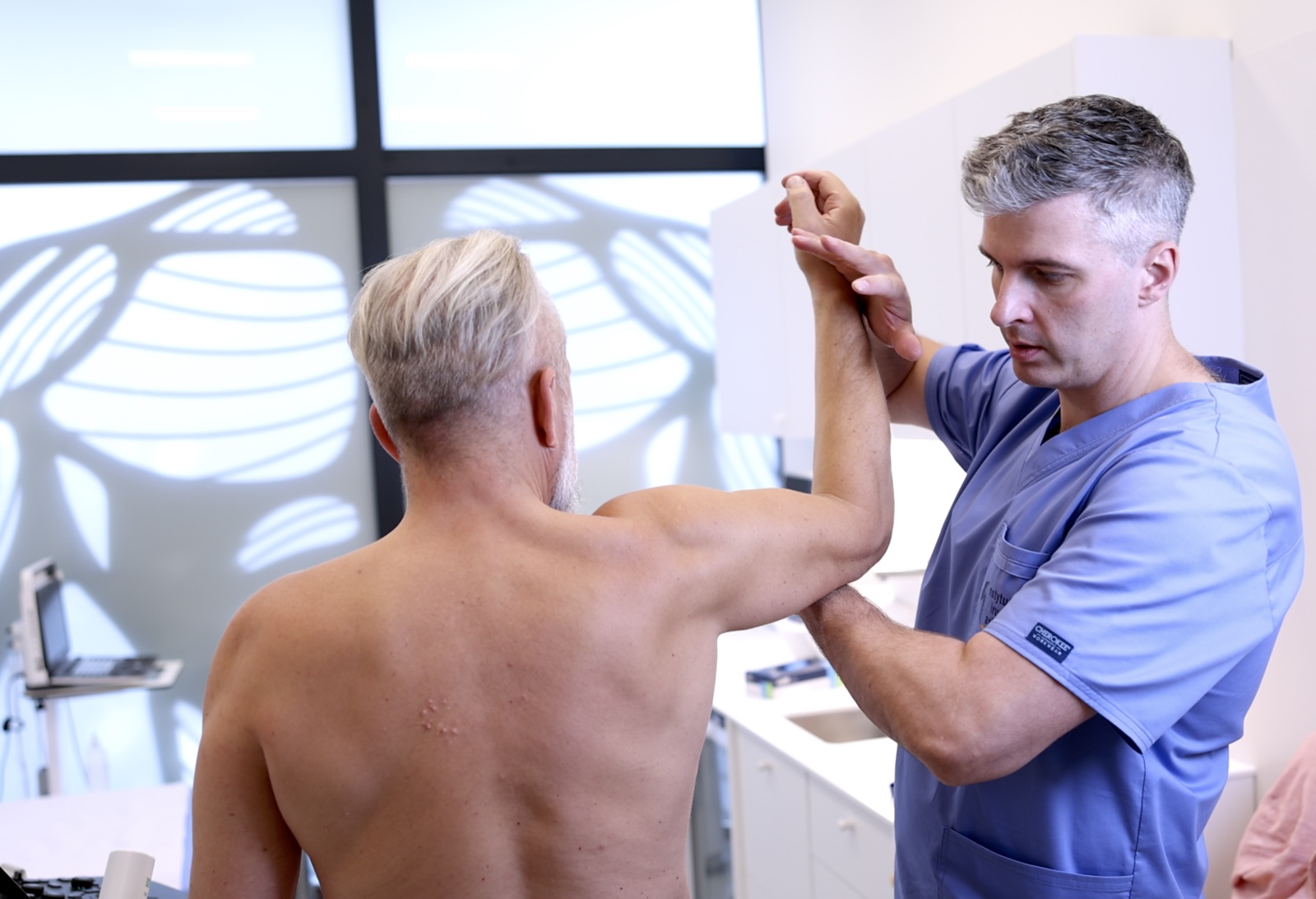 Badanie kliniczne barku w IChB - lekarz wykonuje test oporowy stożka rotatorów